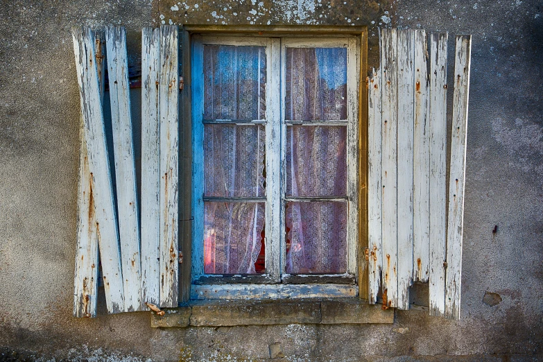 a window with white curtain and red candle