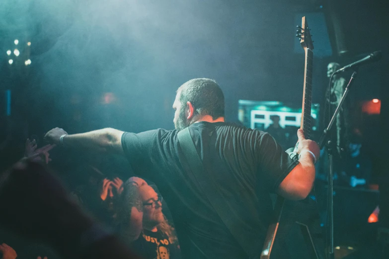 a man standing in front of a microphone on stage