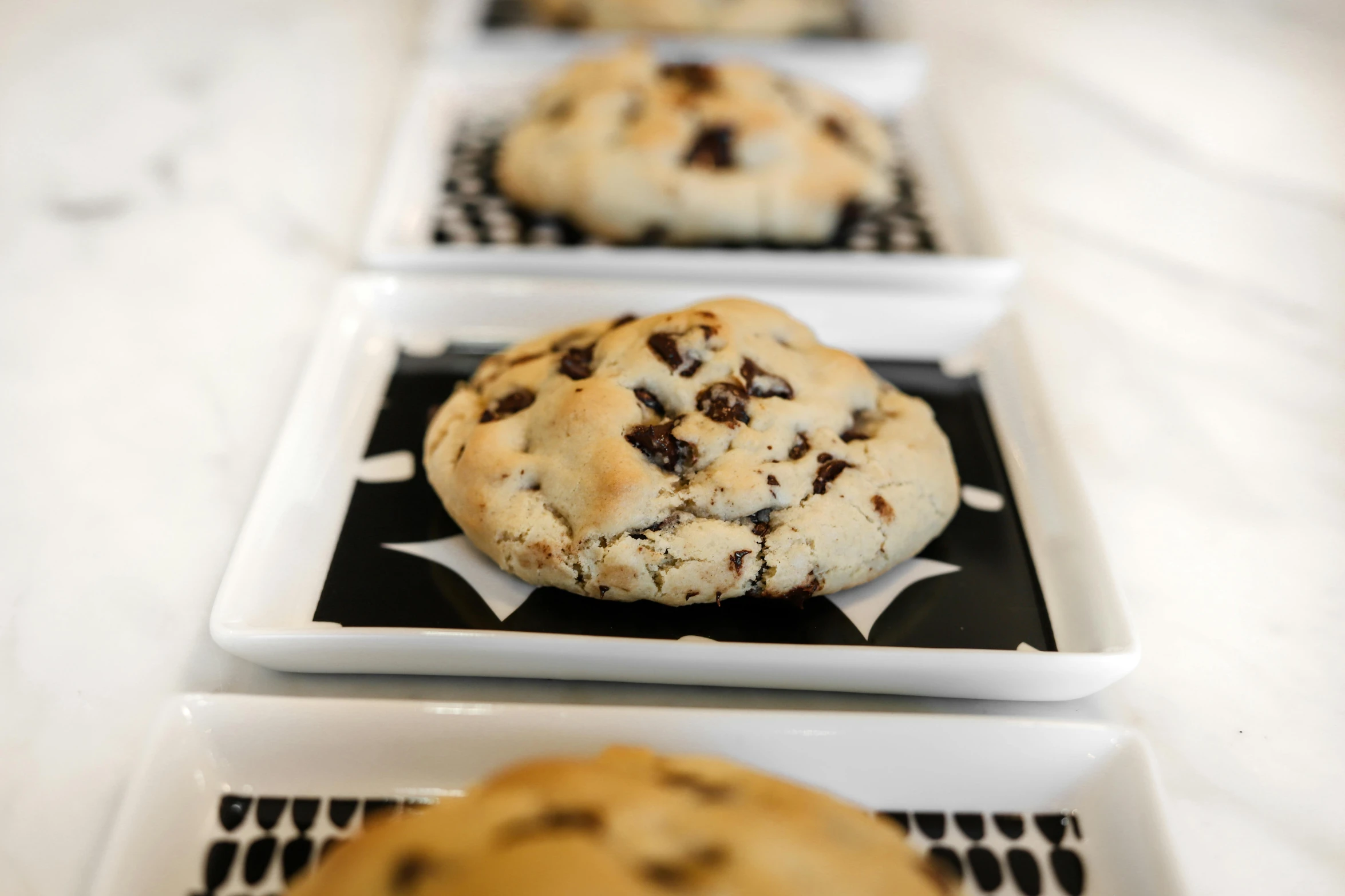 three square trays are full of cookies and one is half eaten