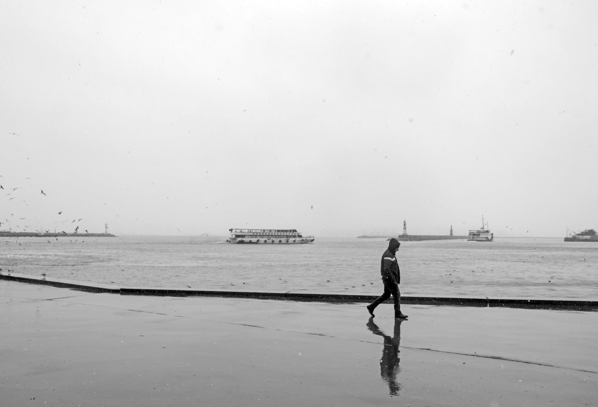 a person is walking on a beach near a boat