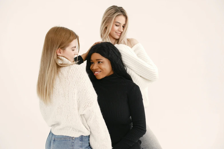 three women wearing white are hugging each other