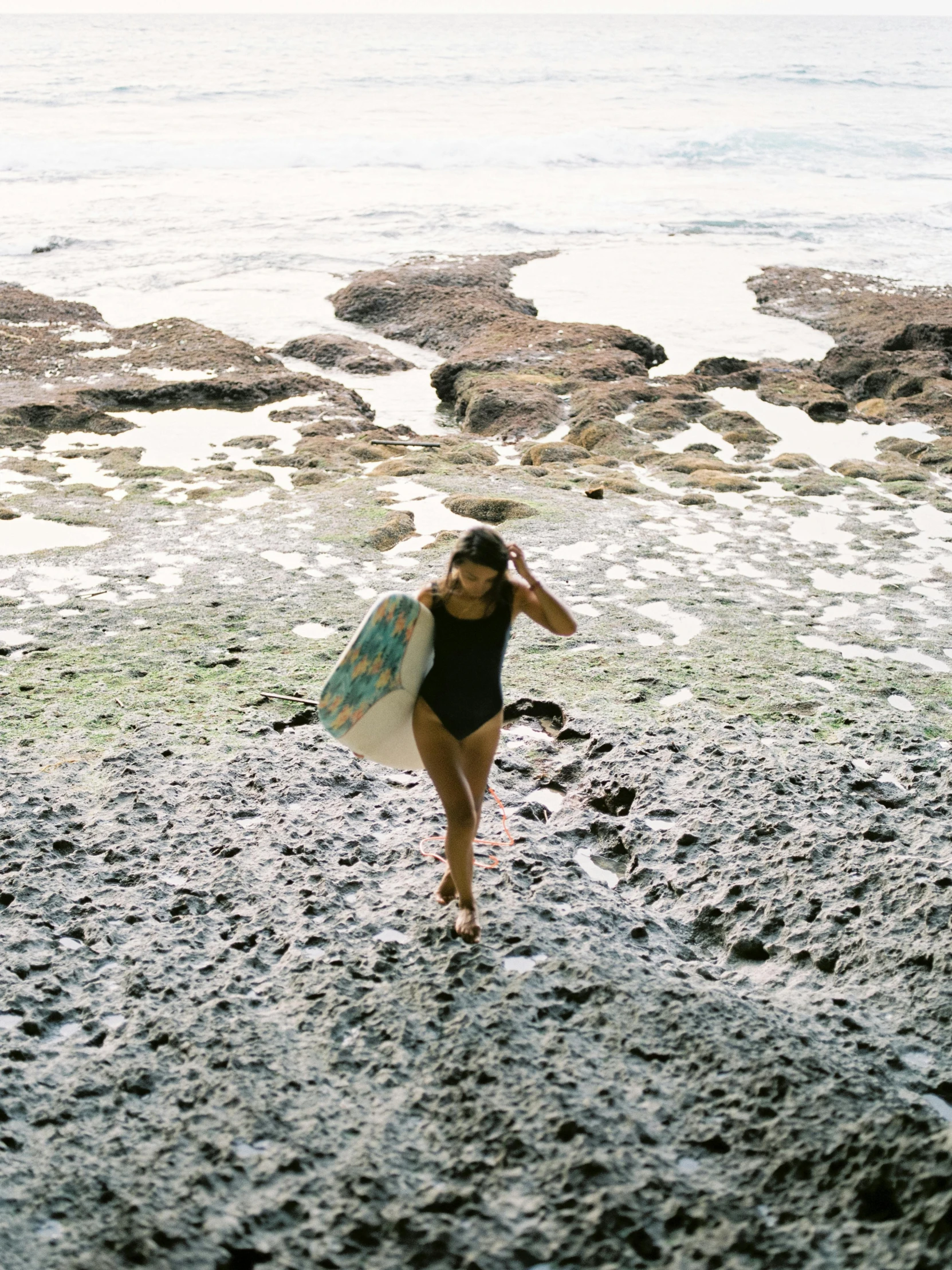 a surfer carrying his board while walking on the beach