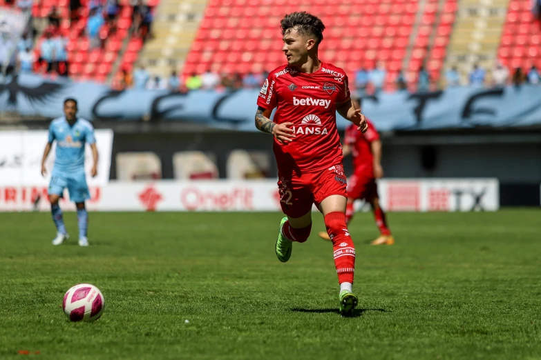 a man running on a soccer field with a soccer ball