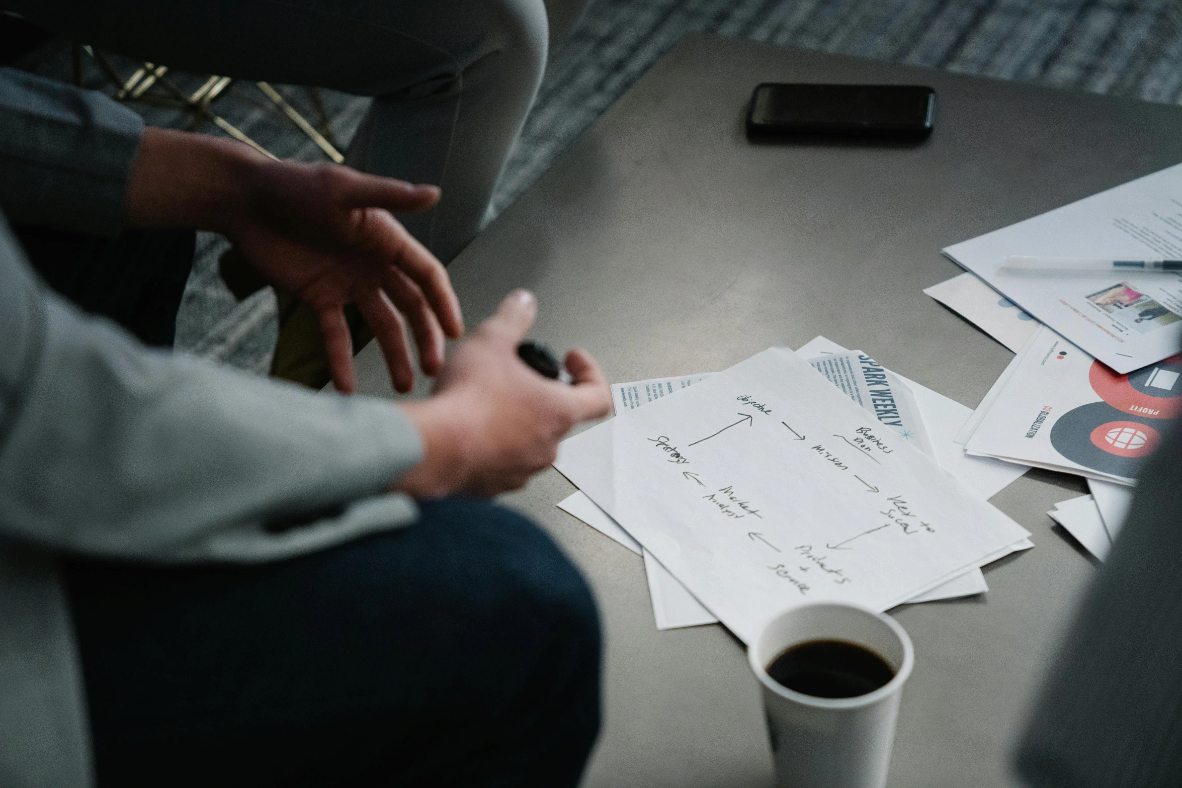 a person sitting at a table with a cup of coffee