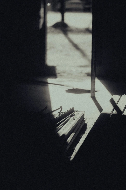 a wooden bench sitting in the shade of the window