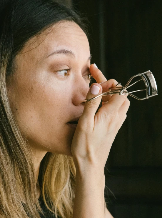 a woman blows her nose with a metal ring