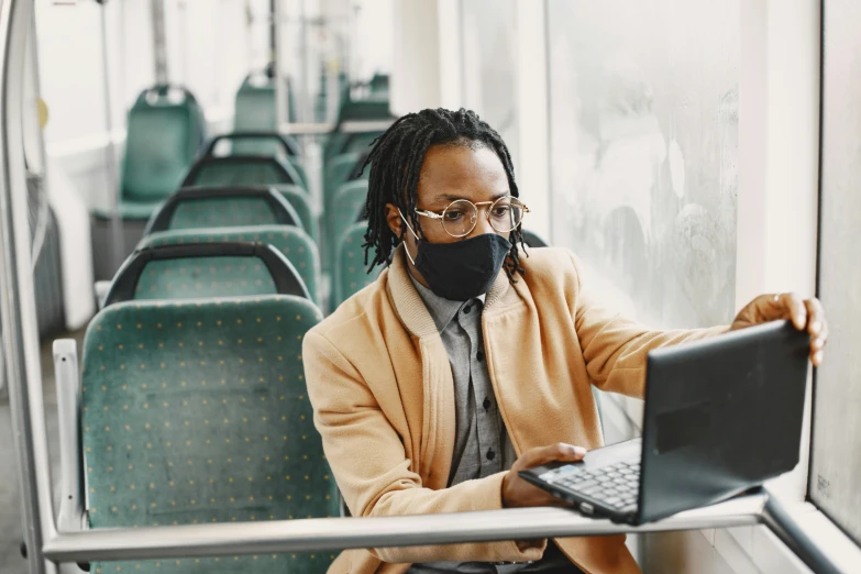 a man on a bus wearing a black mask