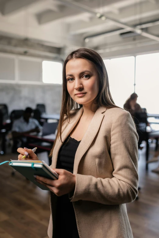 a woman holds a note book in a large conference room