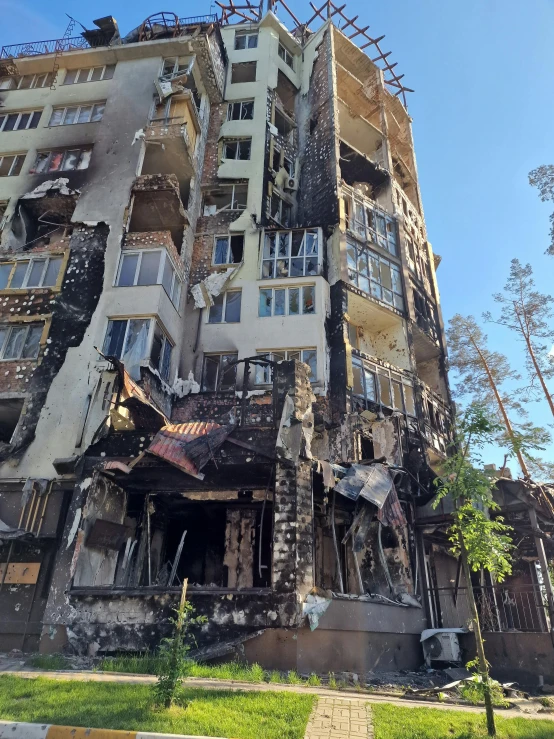 an old apartment building has fire damage in the foreground