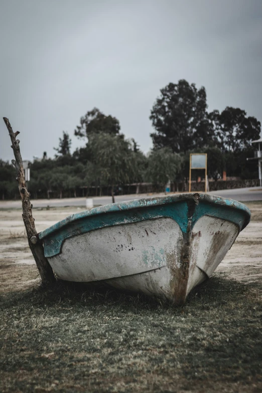 an abandoned white boat in the grass