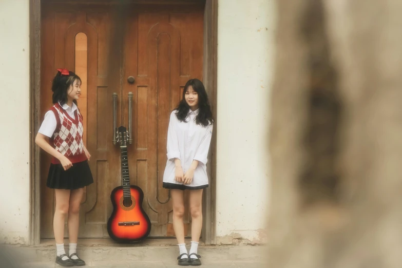 two asian women standing outside next to a door