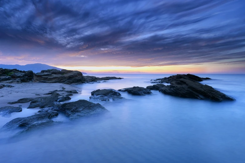 there is a long exposure po of rocks on the water