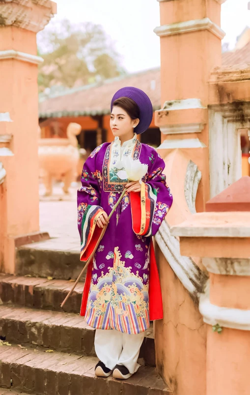 young woman dressed in oriental clothes standing on stairs