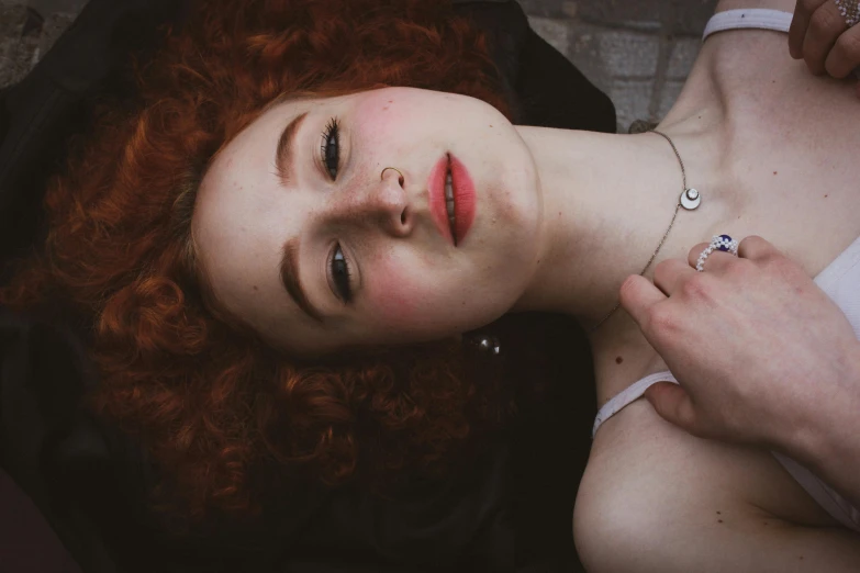 a young woman with red hair is posing for the camera