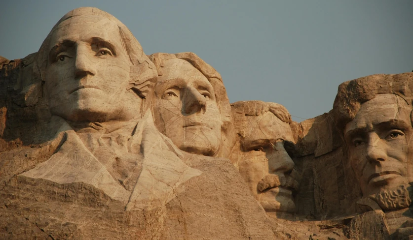 a large group of faces sitting in the middle of a cliff