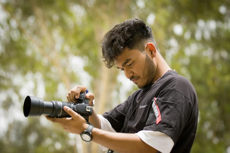 a man is holding a camera and using the lens