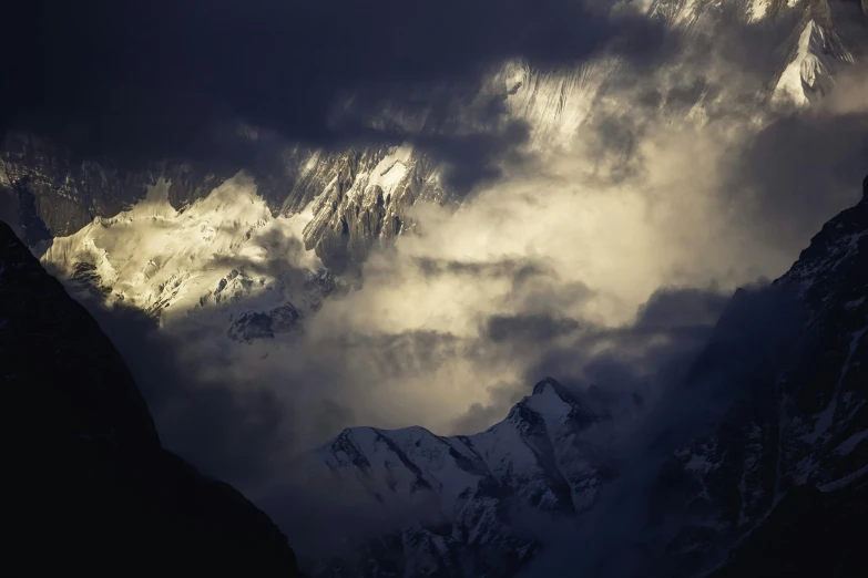 clouds move over the mountains with snow on them