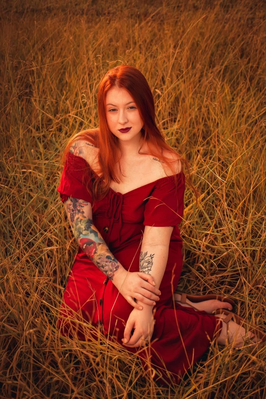 a woman in red dress sitting in grass