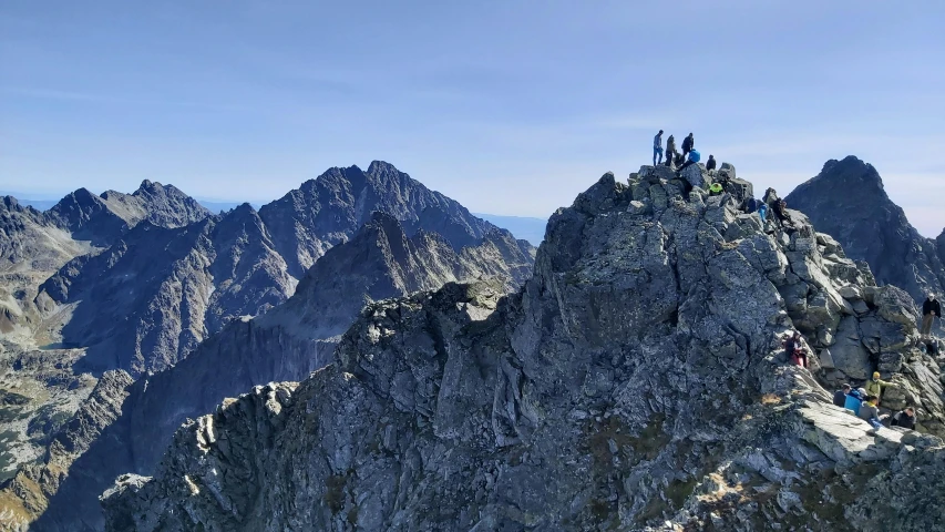 people on top of a large mountain with mountains in the background