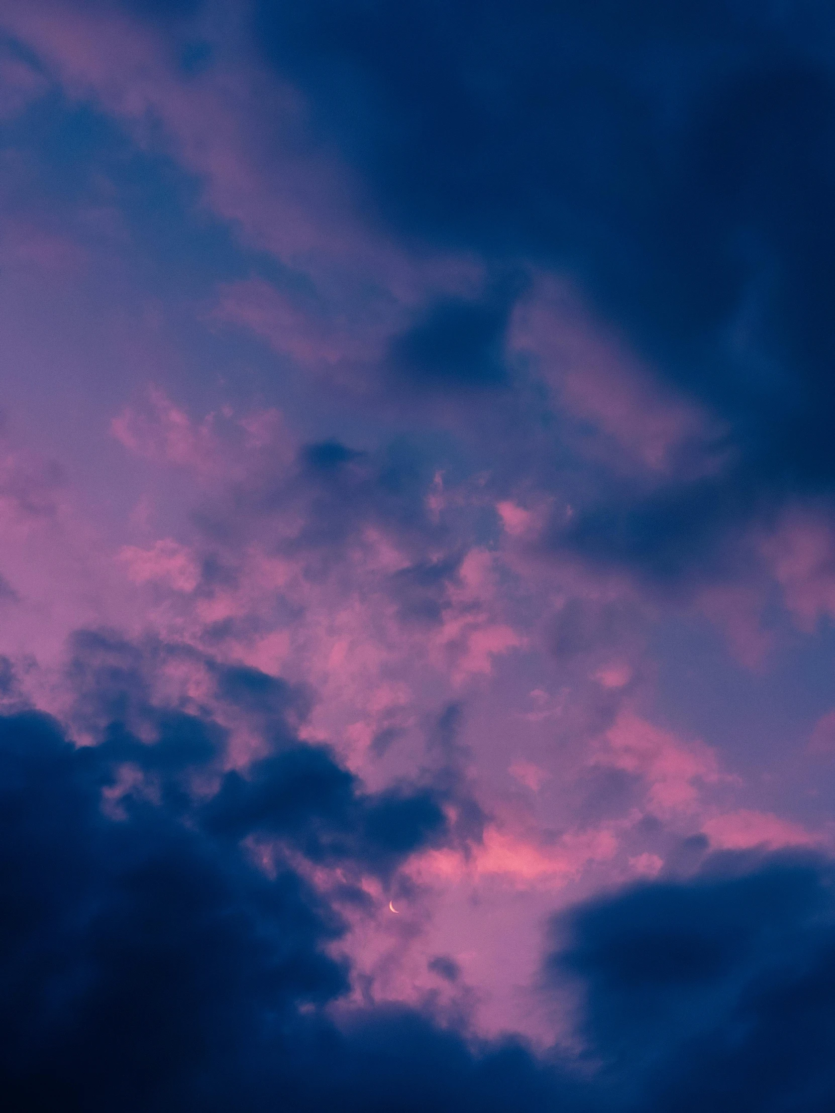 red clouds against blue sky with jet flying below