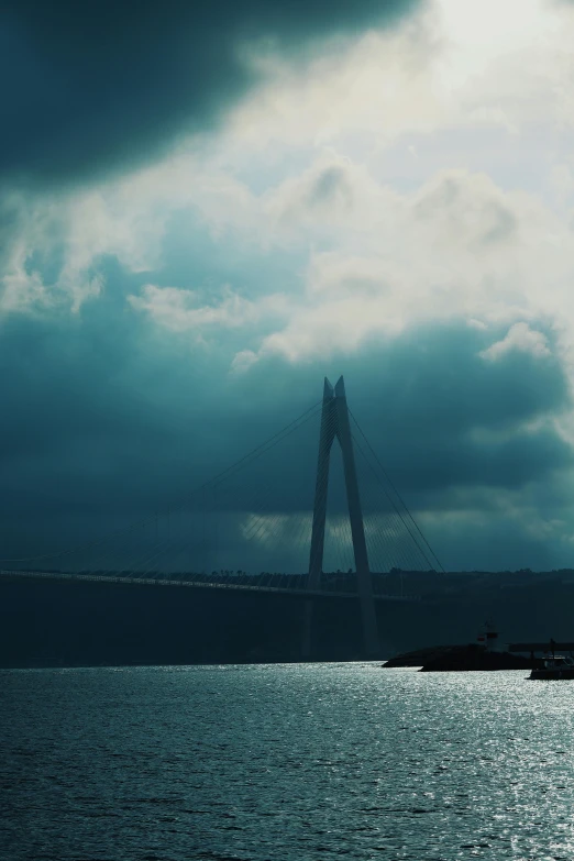 a boat out on the water under a cloudy sky