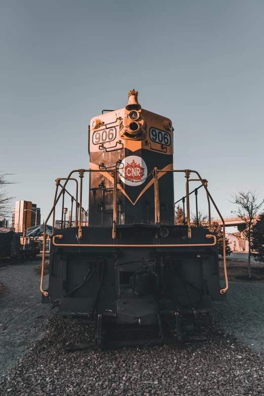 a yellow and black train sits on a gravel surface