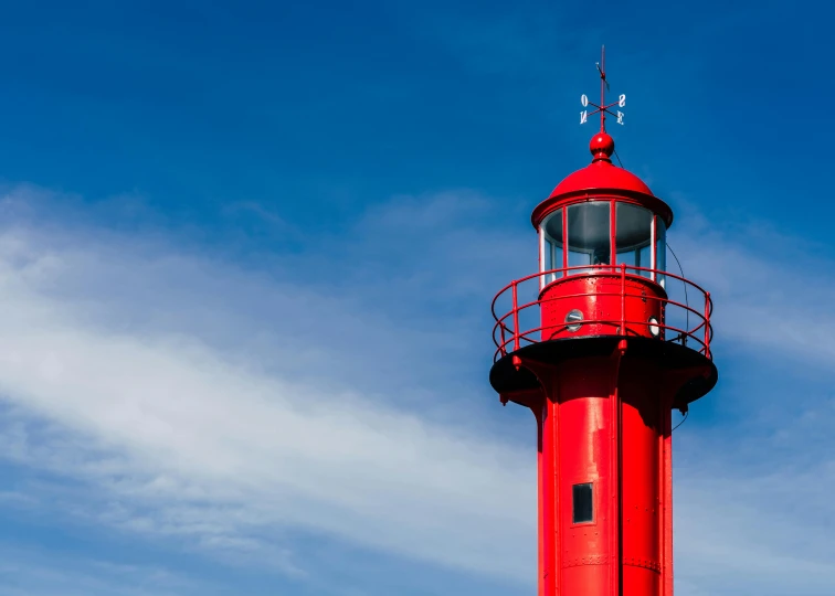 a red lighthouse in the middle of a clear blue sky