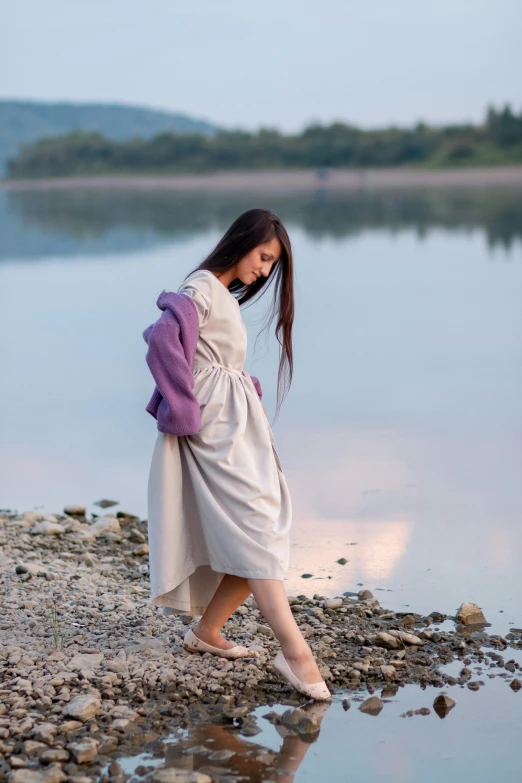 a woman standing on top of a beach near water