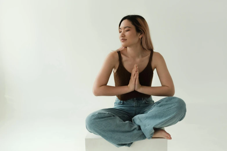 a woman meditating while sitting on top of a block