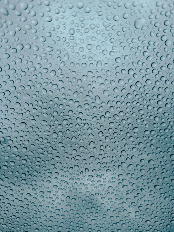 raindrops that look to be falling down the side of a glass window