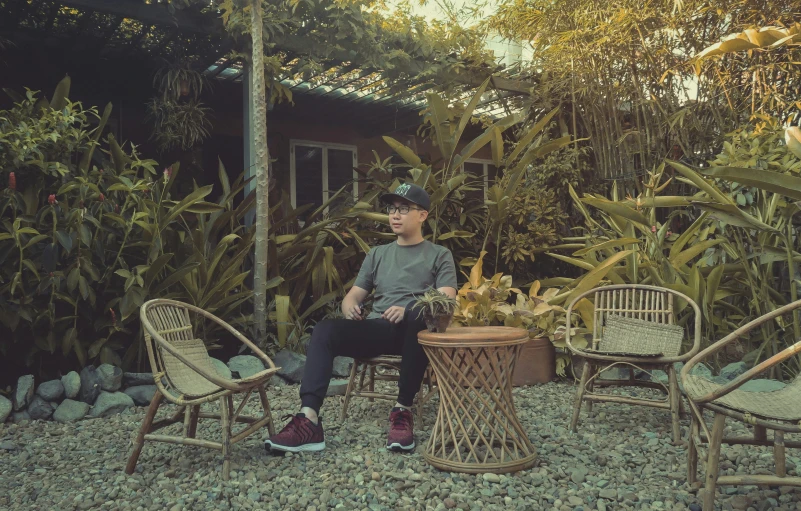 a man sitting at a table in a garden