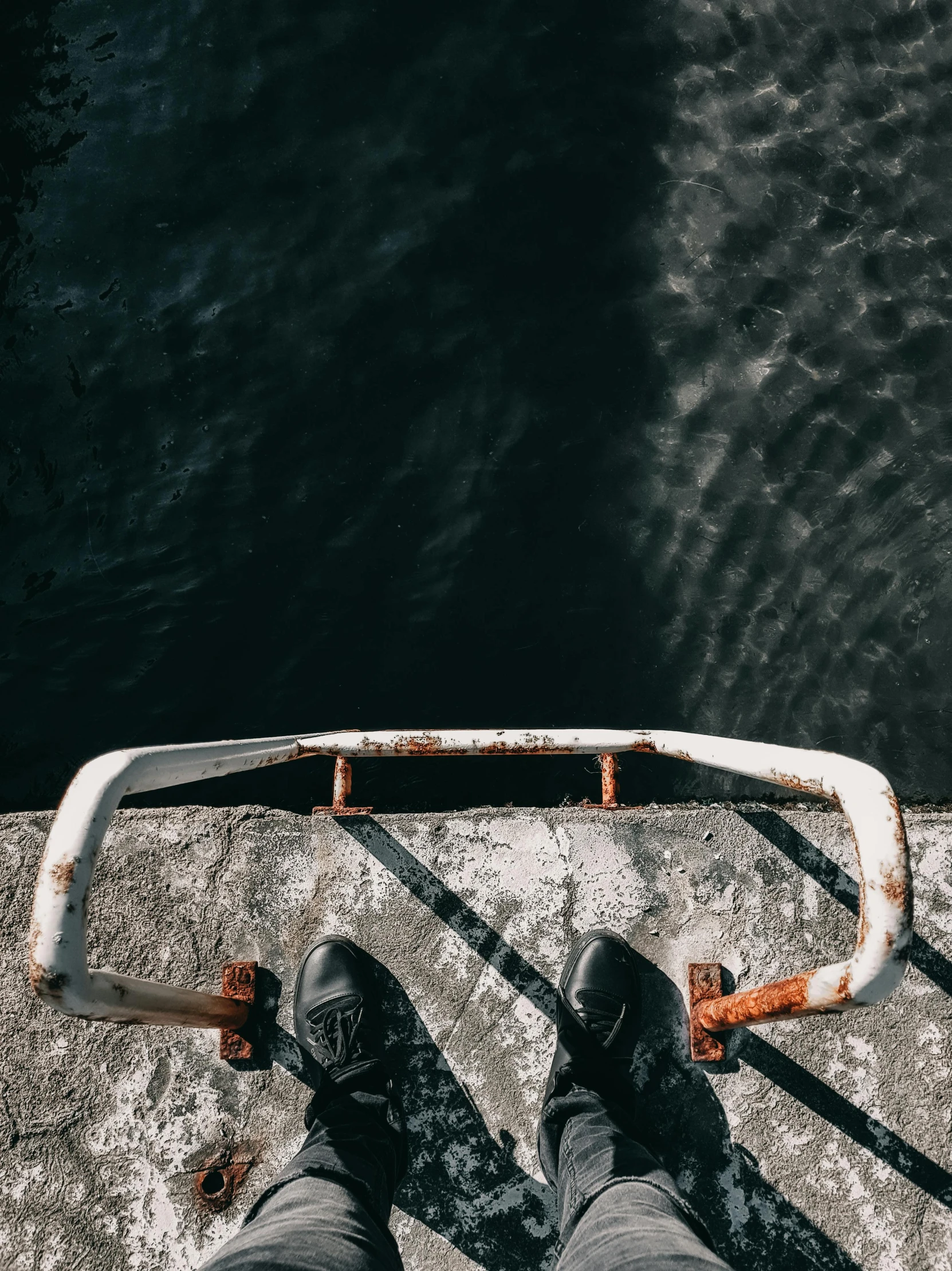 a person standing on top of a rock near the water