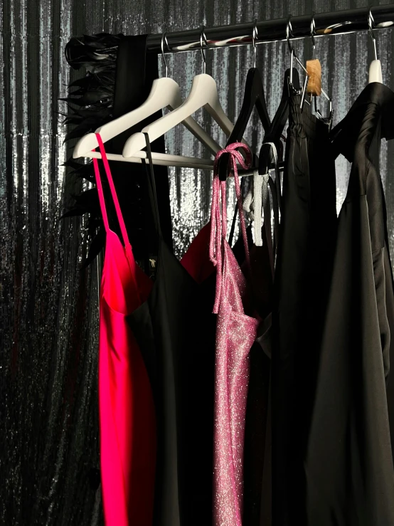 an array of women's dresses are displayed on a rack