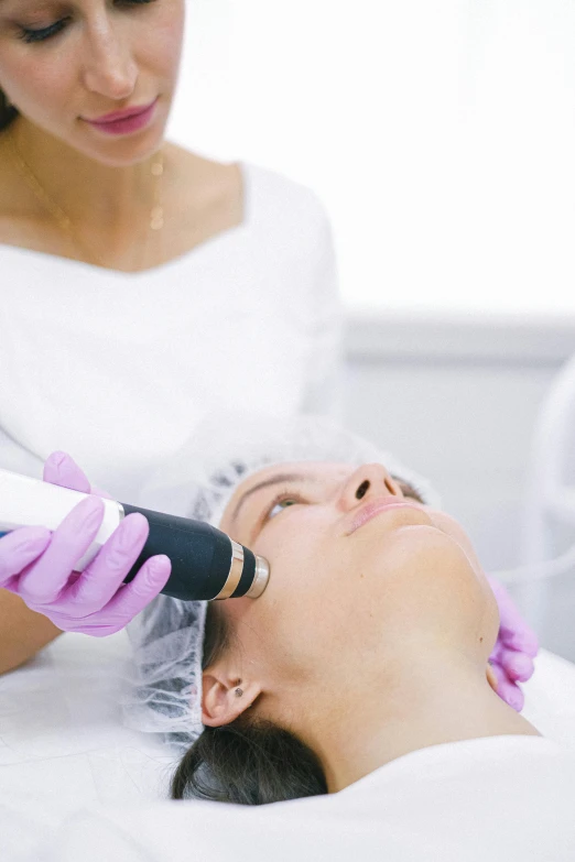 two women at the salon, one is using an epilator