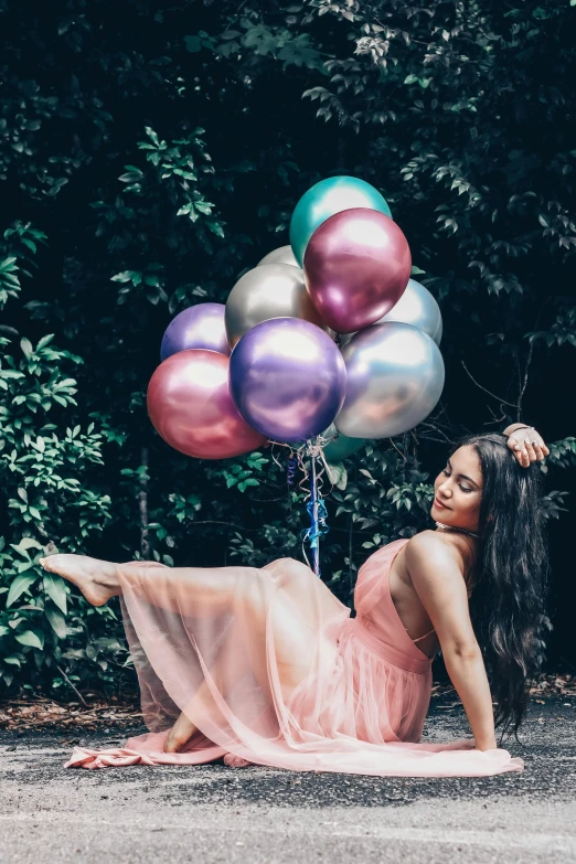 a woman holding multi colored balloons over her head