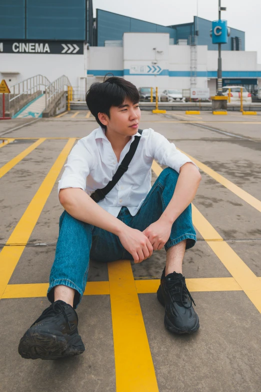 a boy sitting on the ground wearing black shoes