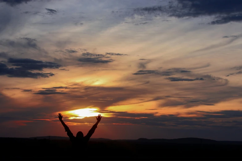 person standing in a field with their arms up