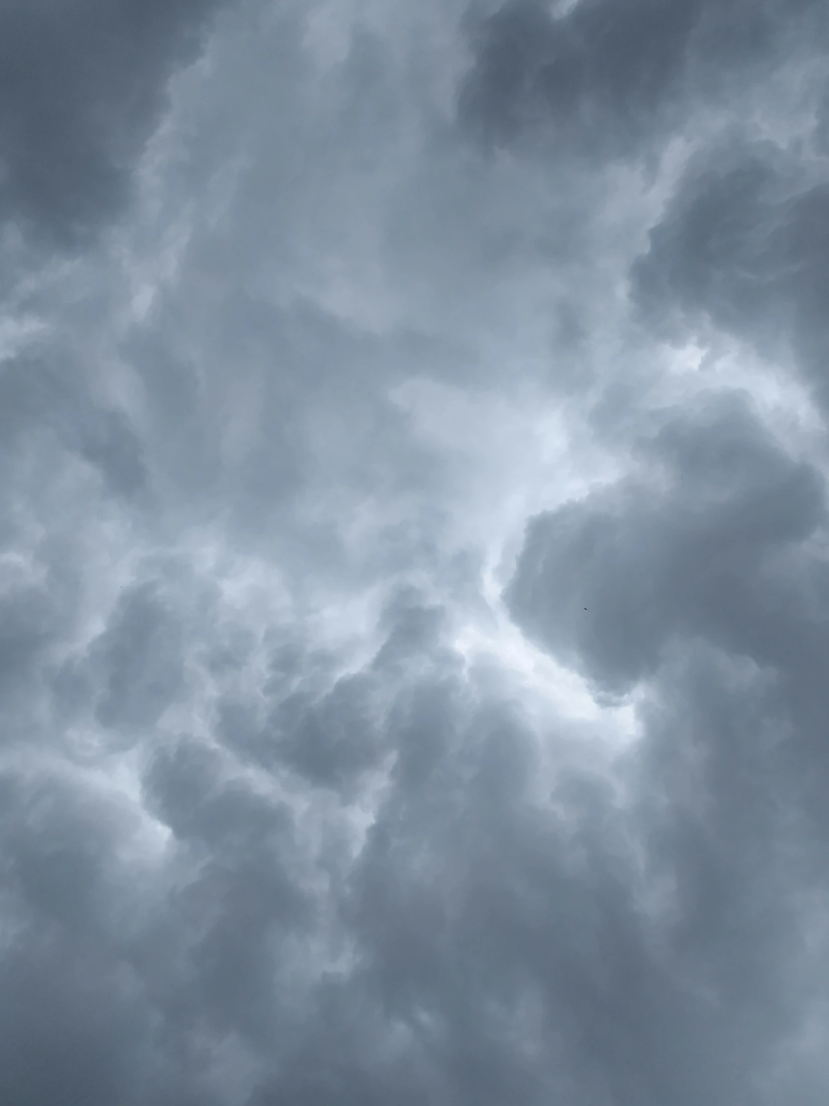 an airplane flying through a cloudy sky with a tail