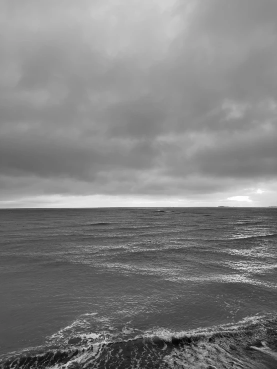 black and white image of a lone boat in the distance
