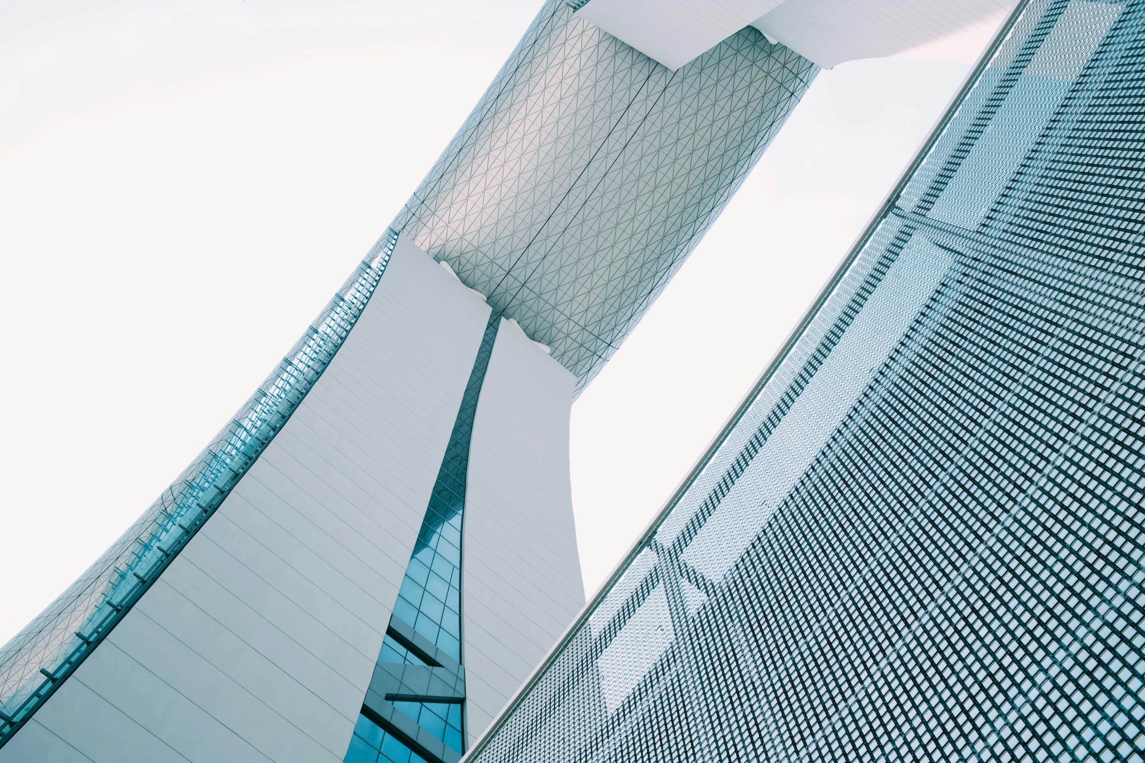 a tall building with windows next to a large white wall