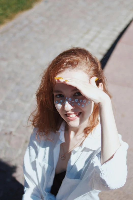 a woman wearing glasses and white shirt standing in the sun