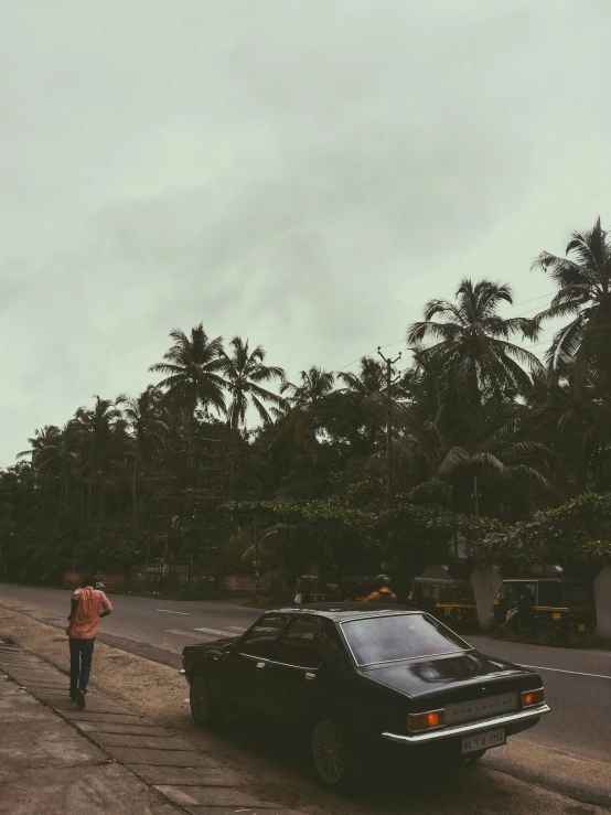 a man is walking toward a parked car