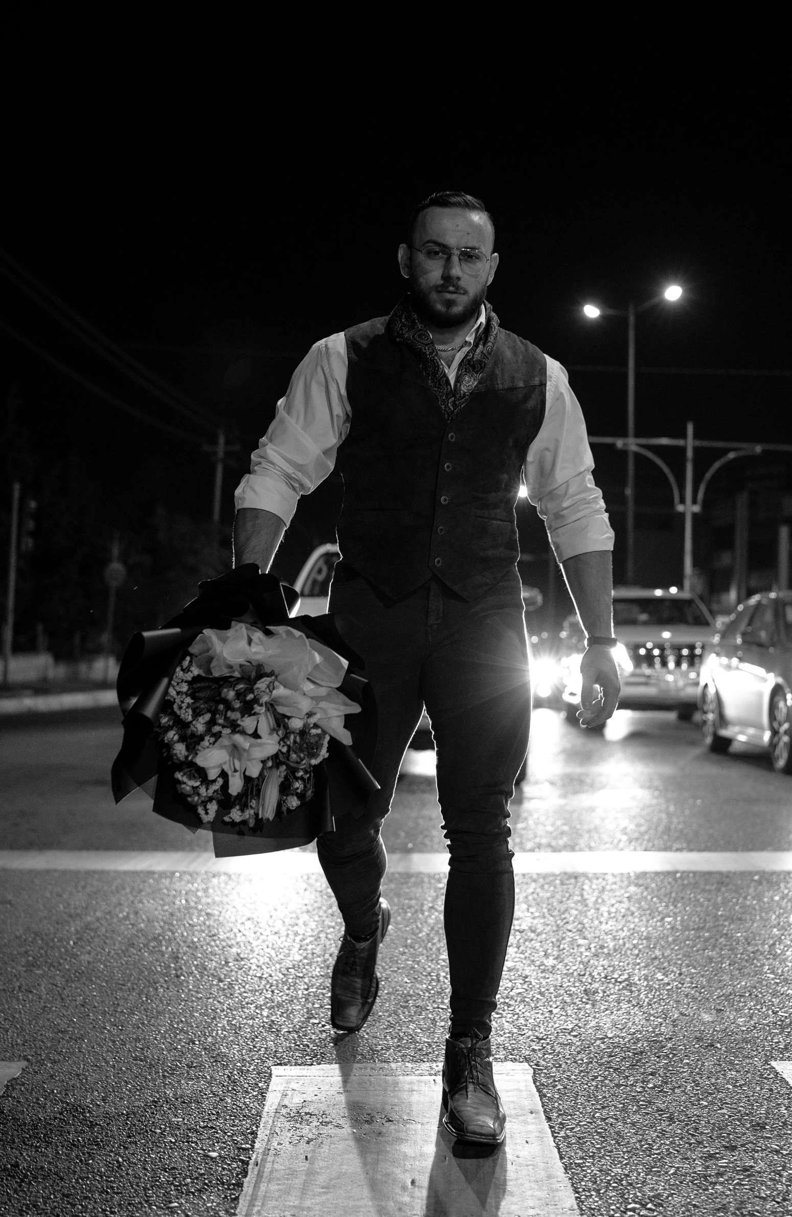 a man in a vest crossing a road at night