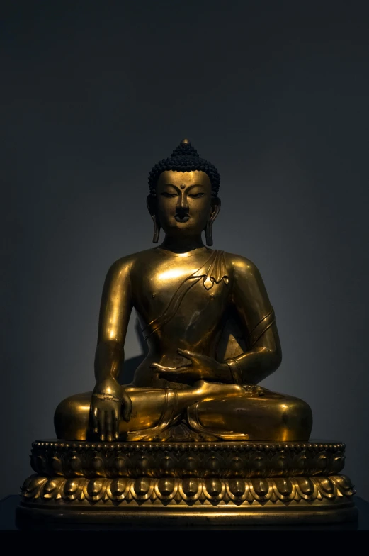 a golden buddha statue with one hand on the ground