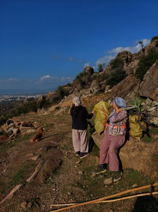 two people sitting on the top of a hill