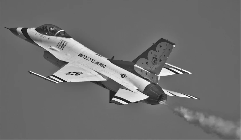 a fighter jet flying through a gray sky