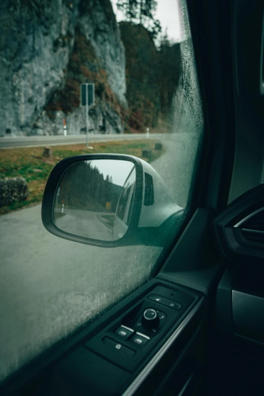 a car with the view of a road in its rearview mirror