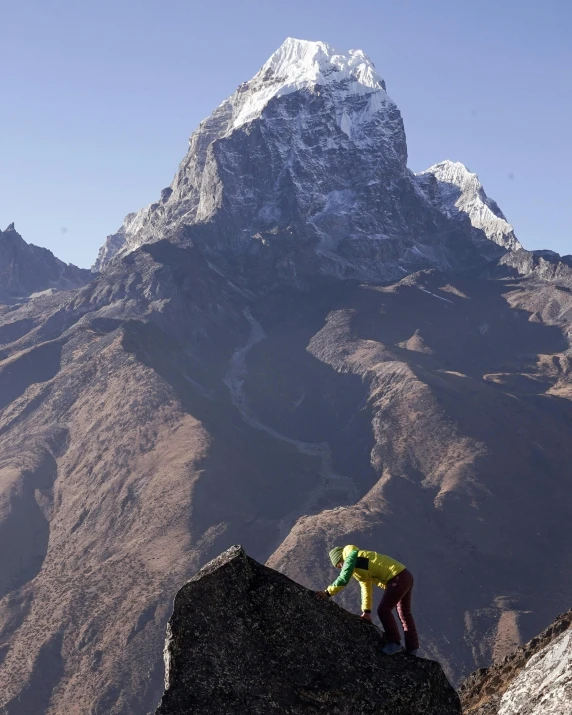 a person on a rocky mountain climbing up a hill