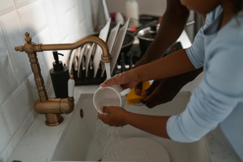 the woman is washing the dishes in the sink