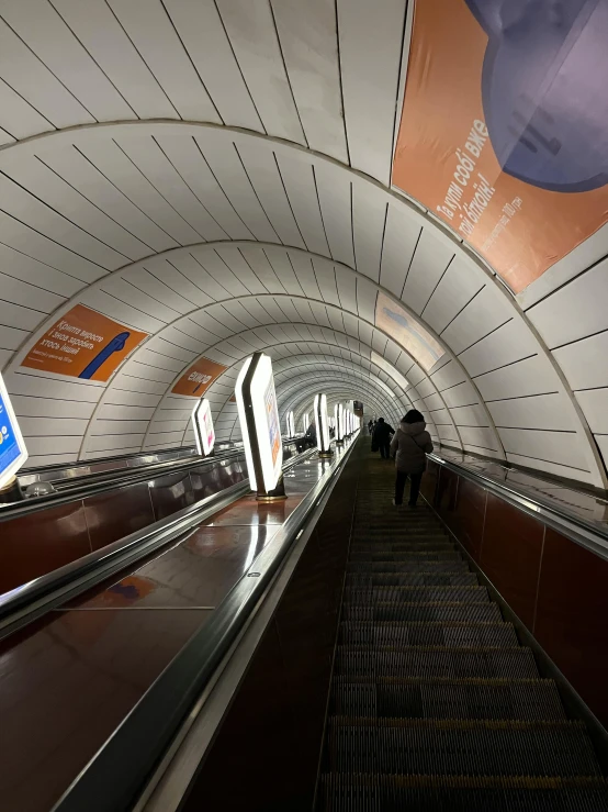 the people are riding down the escalator of the subway